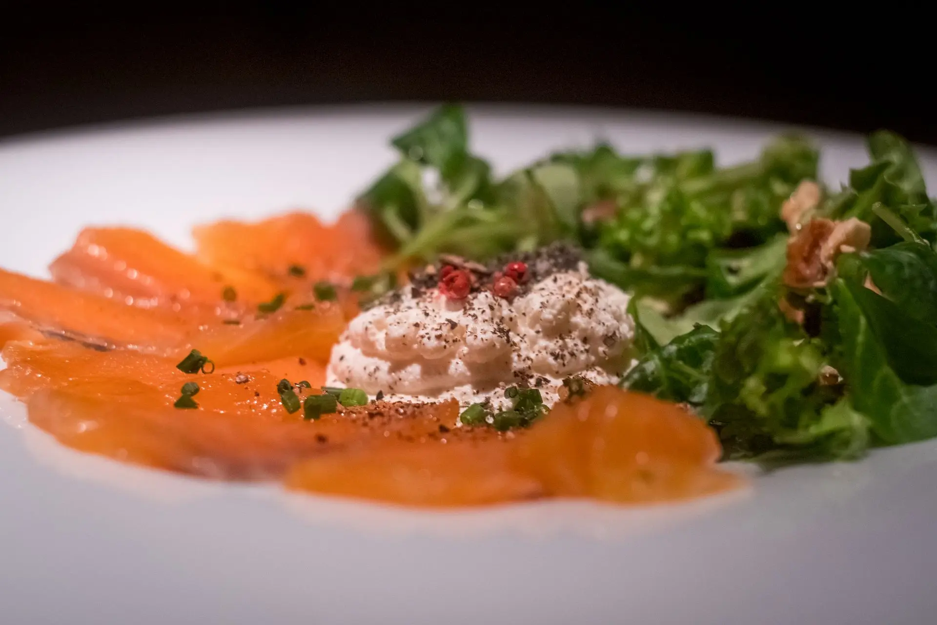 A stunning close-up of a delicate salmon carpaccio, plated with precision by food photographer Louis Mas in Barcelona. The vibrant colors and fresh textures are enhanced by a refined play of light, ideal for restaurant promotions and high-end food branding. As a videographer, Louis Mas crafts captivating culinary narratives, making this image a powerful asset for digital marketing in the hospitality industry.