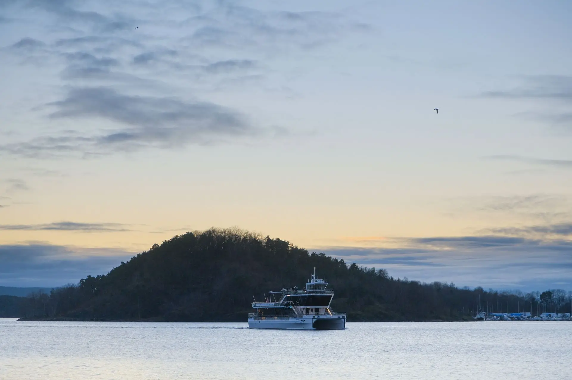 A ferry moves across the calm waters of Oslo as the sky transitions into twilight. The soft gradients of color and the peaceful movement of the boat create a quiet, atmospheric moment. Taken by Louis Mas, photographer and videographer, this image captures the essence of travel and stillness in the city’s landscape.