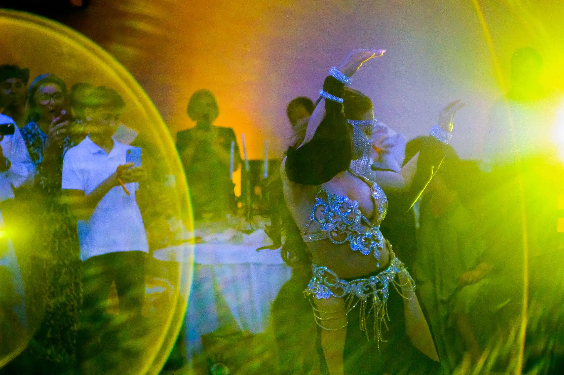 This photograph captures the fluidity and elegance of an oriental dancer in motion, transforming movement into visual poetry. The interplay of light and shadow accentuates the contours of her body, emphasizing the grace and precision of each gesture. The photographer’s skill is evident in the timing—freezing an instant where expression, posture, and flow align harmoniously. The framing allows the viewer to feel the energy of the performance while maintaining a sense of intimacy, as if invited into the rhythm itself. The image is not just a record of movement; it is a celebration of artistry, both in dance and photography.