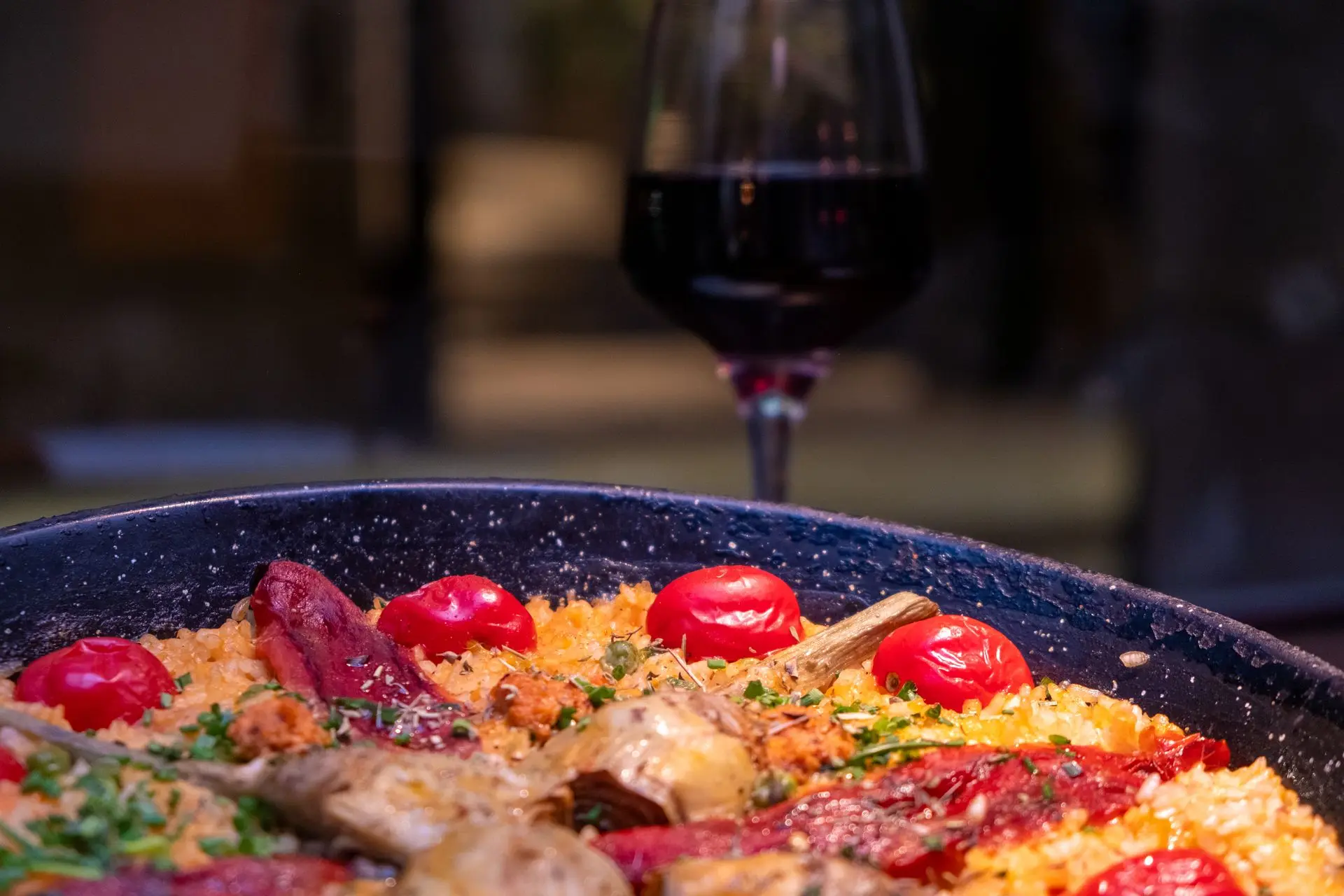 This vibrant paella, captured by food photographer Louis Mas in Barcelona, highlights the richness of Spanish cuisine. The golden saffron-infused rice, roasted red peppers, artichokes, and juicy cherry tomatoes create a stunning composition, complemented by a deep red wine in the background. Perfect for restaurant branding, menu design, and digital marketing in the gastronomy sector. As a videographer, Louis Mas brings an artistic touch, capturing the essence of Mediterranean flavors.